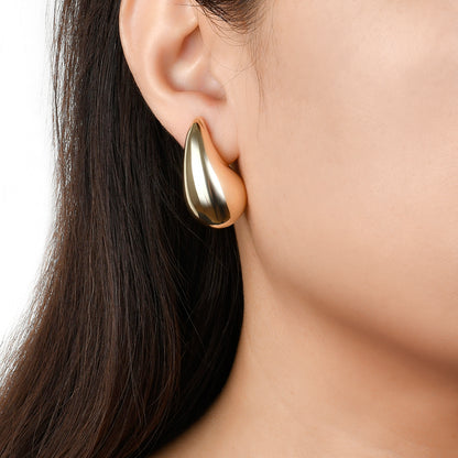 Photo shows model wearing gold chunky dome earrings 